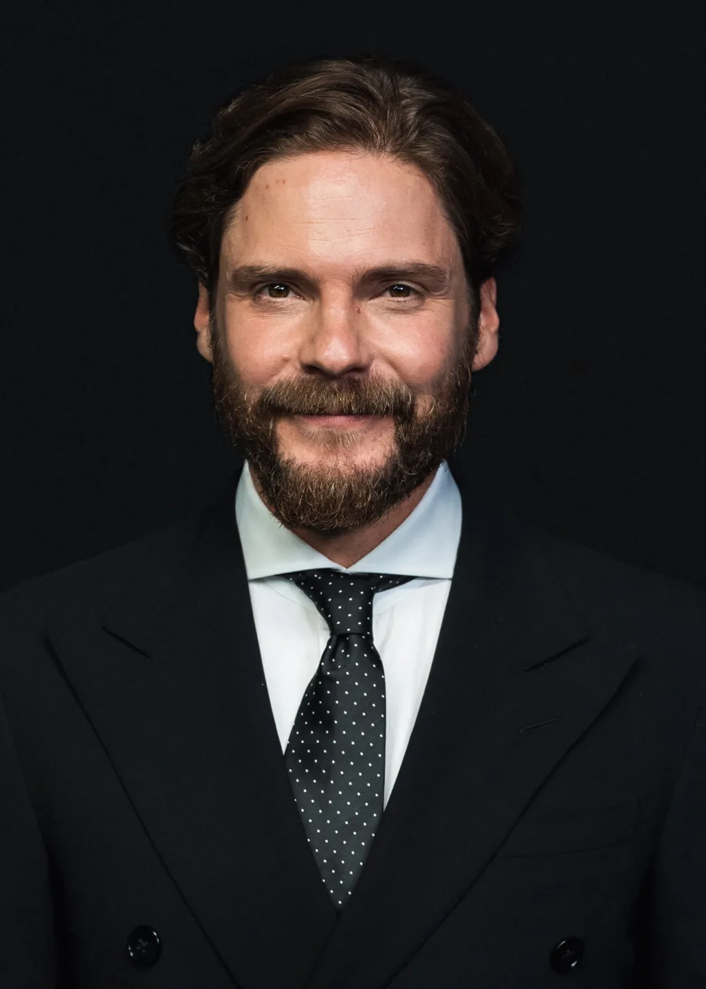 Daniel Brühl is a Spanish-German actor known for his versatile performances in film, television, and theater. Born in Barcelona in 1978, Brühl grew up in a multilingual household and developed a passion for acting at an early age. He made his film debut in 2001 with the German film 