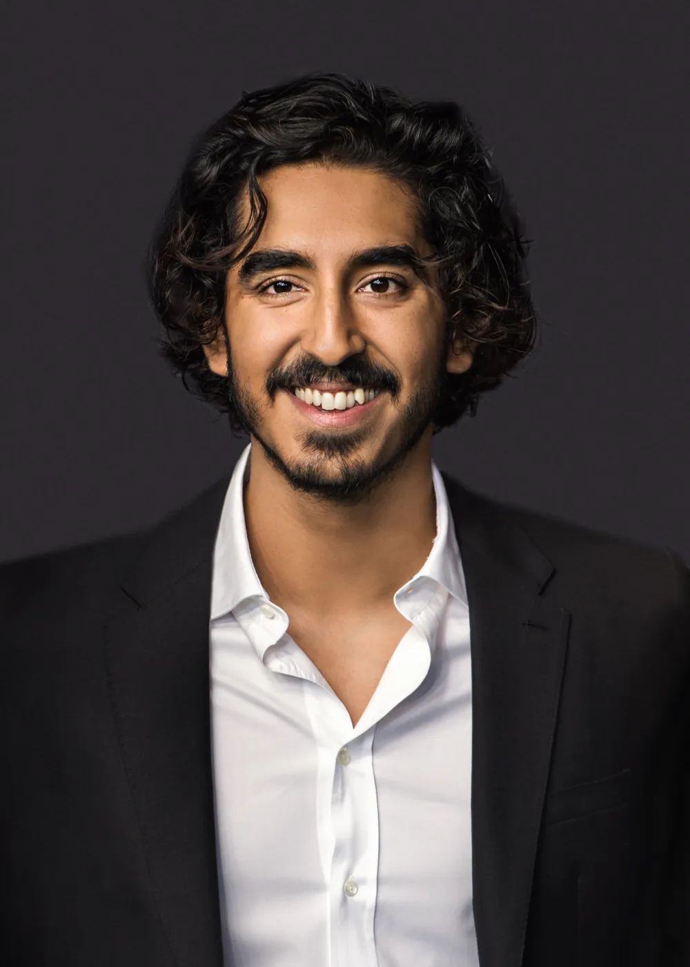 Dev Patel is a British actor known for his dynamic performances on screen and his dedication to his craft. Born on April 23, 1990, in London, England, Patel began his acting career in his late teens, appearing in the popular British television series Skins before making his feature film debut in Slumdog Millionaire. Patel is known for his ability to convey deep emotions and inhabit a wide range of characters, from sympathetic to complex and challenging. He has received widespread critical acclaim for his work in films like Lion, The Personal History of David Copperfield, and The Green Knight, and has been nominated for numerous awards, including an Academy Award and a Golden Globe. In addition to his acting career, Patel is also a philanthropist, supporting various charitable organizations and causes, including the Teenage Cancer Trust and the Dalit Children Foundation. With his impressive talent, dedication, and generosity, Patel has become one of the most respected and admired actors of his generation, known for his ability to captivate audiences with his powerful and nuanced performances.